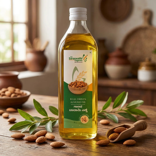 Bottle of Saraswath Organics almond oil on a wooden table with almonds and leaves.