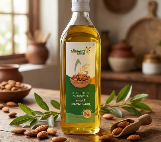 Bottle of Saraswath Organics almond oil on a wooden table with almonds and leaves.