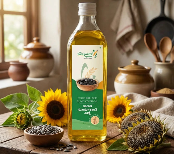 Bottle of Saraswathi Organics sunflower oil on a wooden table with sunflowers and seeds.
