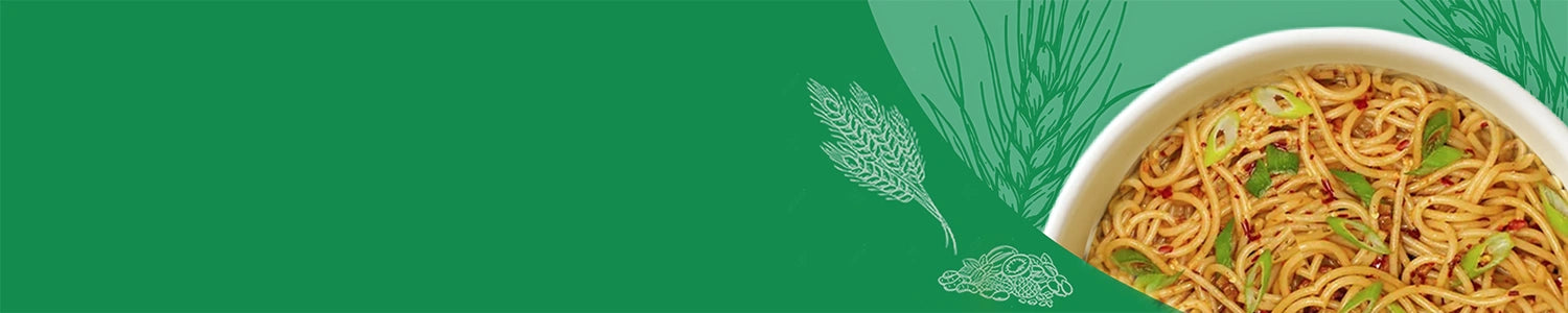 Noodles in a bowl with green leaves on a green background